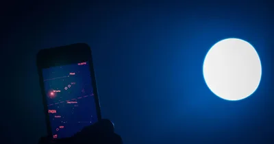 چشم انسان در حال رصد آسمان شب با گوشی هوشمند و فیلتر قرمز